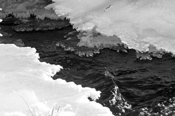 Eisplatte über dem Bachlauf